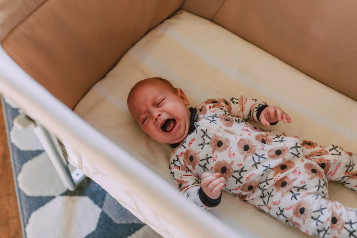 Baby crying at bedtime in travel cot